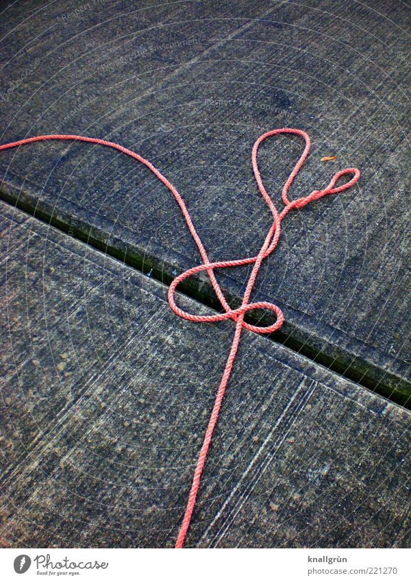 Cast off! Rope Lie Gray Safety Orange safety line Colour photo Exterior shot Deserted Copy Space left Copy Space top Red 1 Thrown down Concrete floor