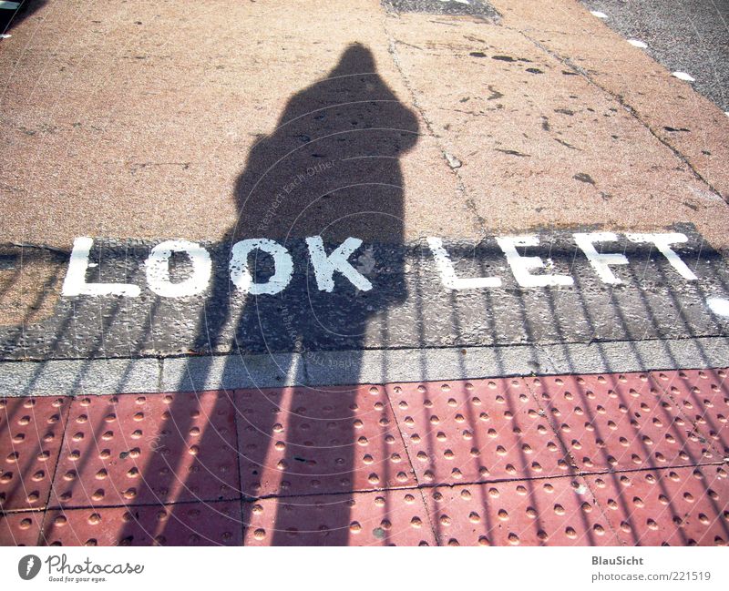 traverse Human being Shadow Street Colour photo Exterior shot Day Pedestrian crossing Characters Block capitals Silhouette Tar Asphalt Floor covering