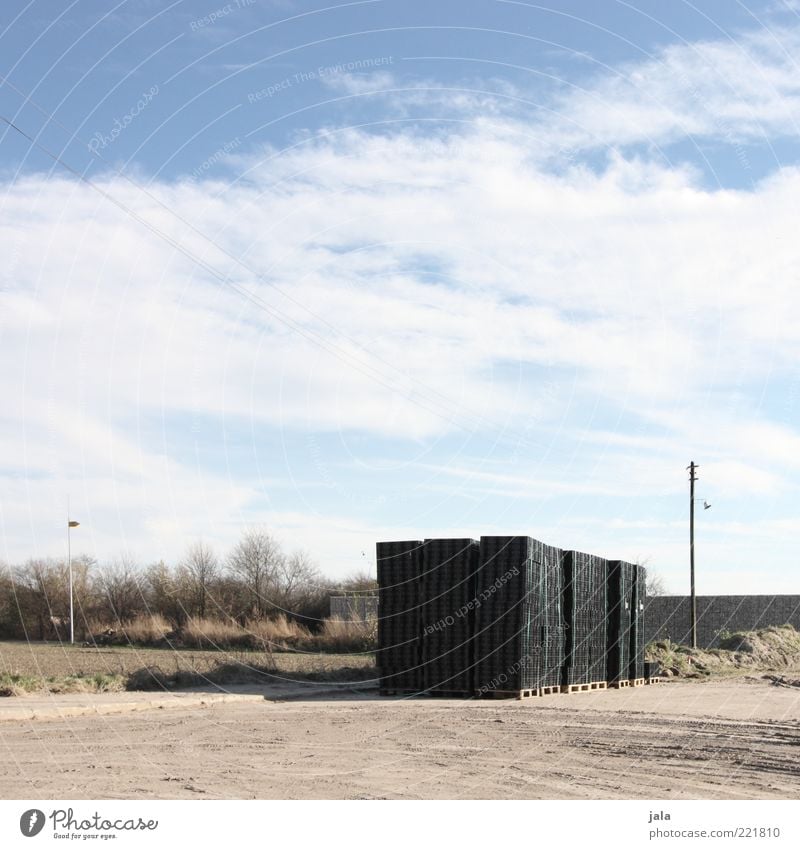 construction site Construction site Landscape Sky Clouds Plant Tree Bushes Lantern Blue Black Stone Stack Palett Beige Colour photo Exterior shot Deserted