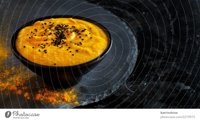 Fresh pumpkin soup in a bowl on a dark background Vegetable Soup Stew Vegetarian diet Bowl Thanksgiving Hallowe'en Autumn Dark Delicious Yellow Black Colour