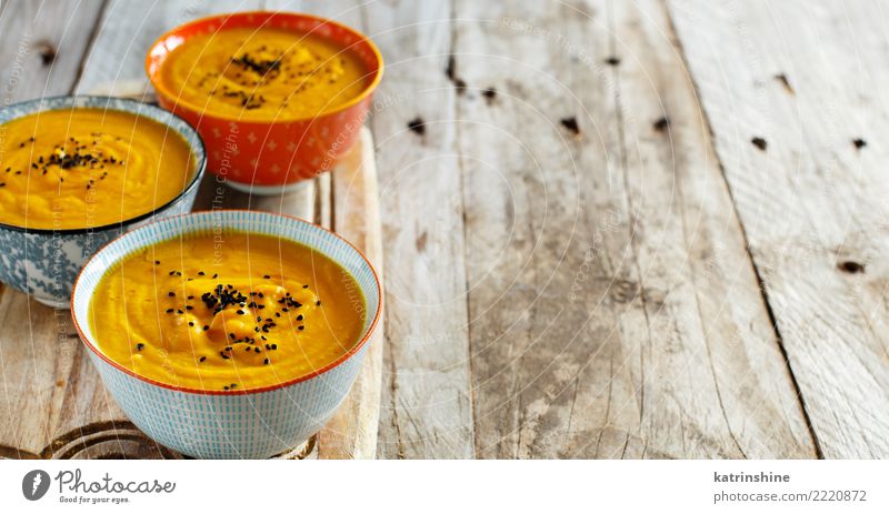 Fresh pumpkin soup in three bowls on a wooden table Vegetable Soup Stew Vegetarian diet Bowl Table Thanksgiving Hallowe'en Autumn Delicious Yellow Colour fall