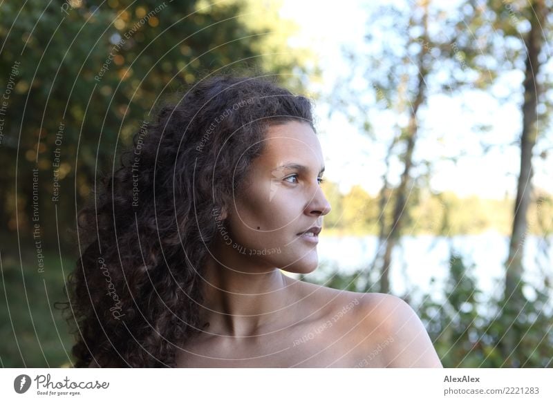 Side portrait of tall beautiful woman with long dark curly hair in nature pretty Harmonious Well-being Young woman Youth (Young adults) Hair and hairstyles Face