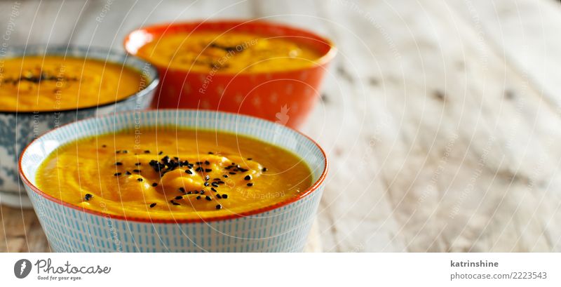 Fresh pumpkin soup in three bowls on a wooden table Vegetable Soup Stew Vegetarian diet Bowl Table Thanksgiving Hallowe'en Autumn Delicious Yellow Colour fall