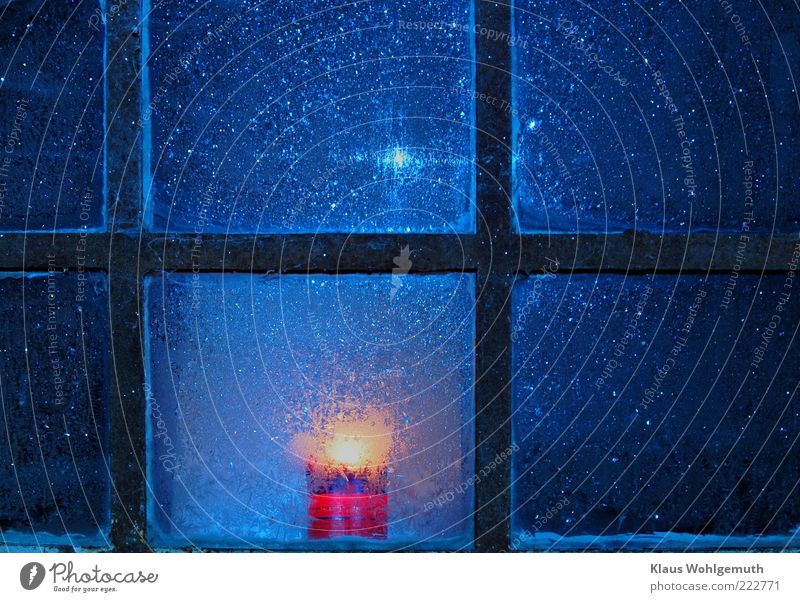 Lonely candle burns behind rusty muntin window with ice trees Calm Decoration Winter Ice Frost Building Window Glass Crystal Freeze Illuminate Blue Gold Black