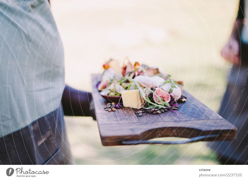 Waiter serving cheese platter in restaurant Cheese Eating Diet Restaurant Wood Fresh Delicious board waiter food wine Fig Delicatessen Diary Colour photo