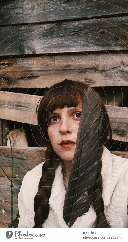 Young woman looking away holding a feather Exotic Beautiful Skin Face Freckles Human being Feminine Youth (Young adults) 1 18 - 30 years Adults Jacket