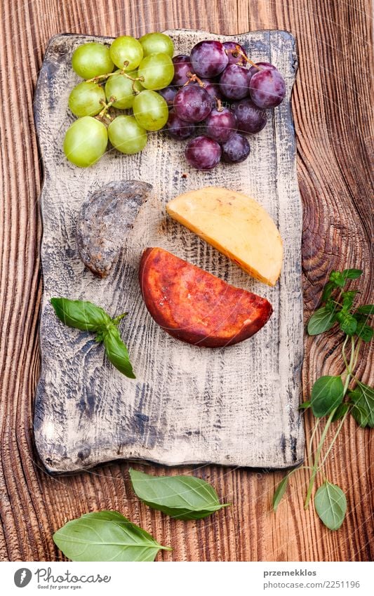 Cheese and grapes decorated on handmade pottery plate Food Fruit Nutrition Breakfast Lunch Plate Table Wood Rust Fresh Delicious Above Basil ceramic Cooking