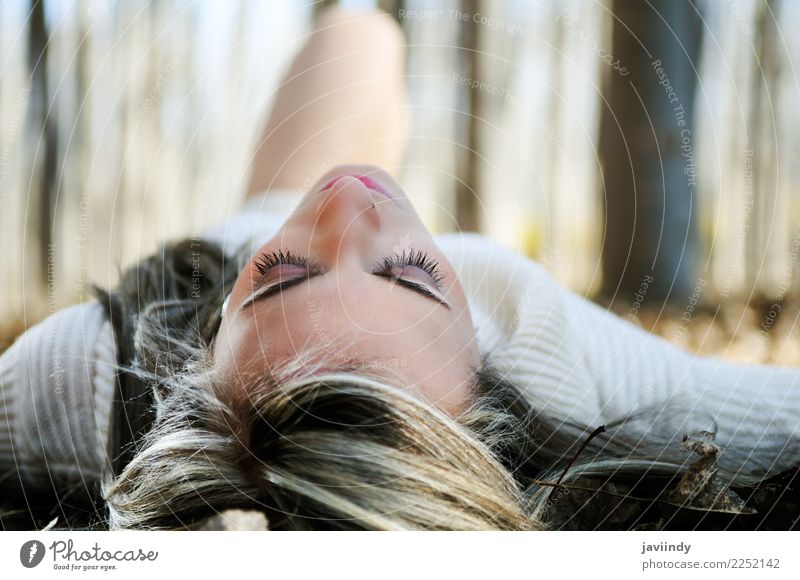 Beautiful blonde girl lying on leaves in a forest of poplars Lifestyle Relaxation Winter Human being Feminine Woman Adults 1 18 - 30 years Youth (Young adults)