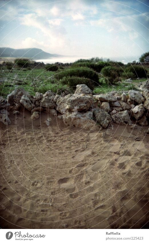 until the wind turns Landscape Earth Sand Air Water Sky Clouds Plant Grass Bushes Mountain Coast Blue Brown Green Footprint Rock Stone Morocco Colour photo