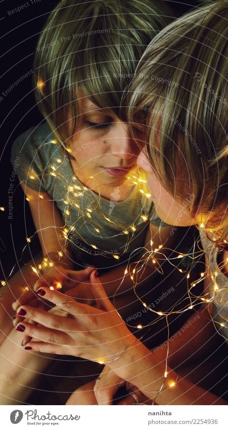 Young woman rounded by christmas lights is reflected in a mirror Design Body Hair and hairstyles Face Feasts & Celebrations Christmas & Advent New Year's Eve