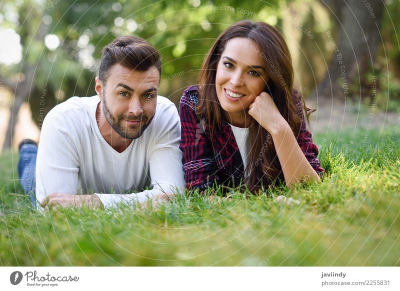 Beautiful young couple laying on grass in an urban park Lifestyle Joy Happy Summer Human being Masculine Feminine Young woman Youth (Young adults) Young man