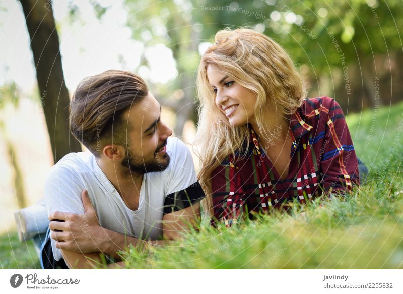 Beautiful young couple laying on grass in an urban park Lifestyle Joy Happy Summer Human being Masculine Feminine Young woman Youth (Young adults) Young man