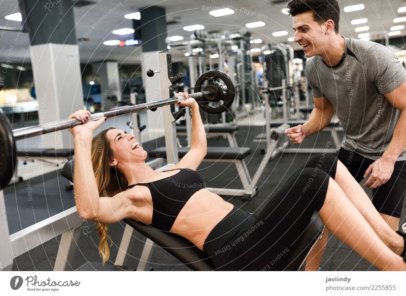 Personal trainer motivating a young woman lift weights Lifestyle Body Sports Human being Masculine Feminine Young woman Youth (Young adults) Young man Woman