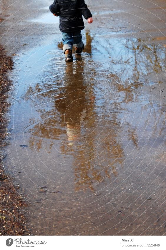 slobbering Human being Child Toddler Infancy 1 1 - 3 years Water Autumn Weather Bad weather Rain Jacket Rubber boots Going Cold Wet Puddle Muding Dirty Playing