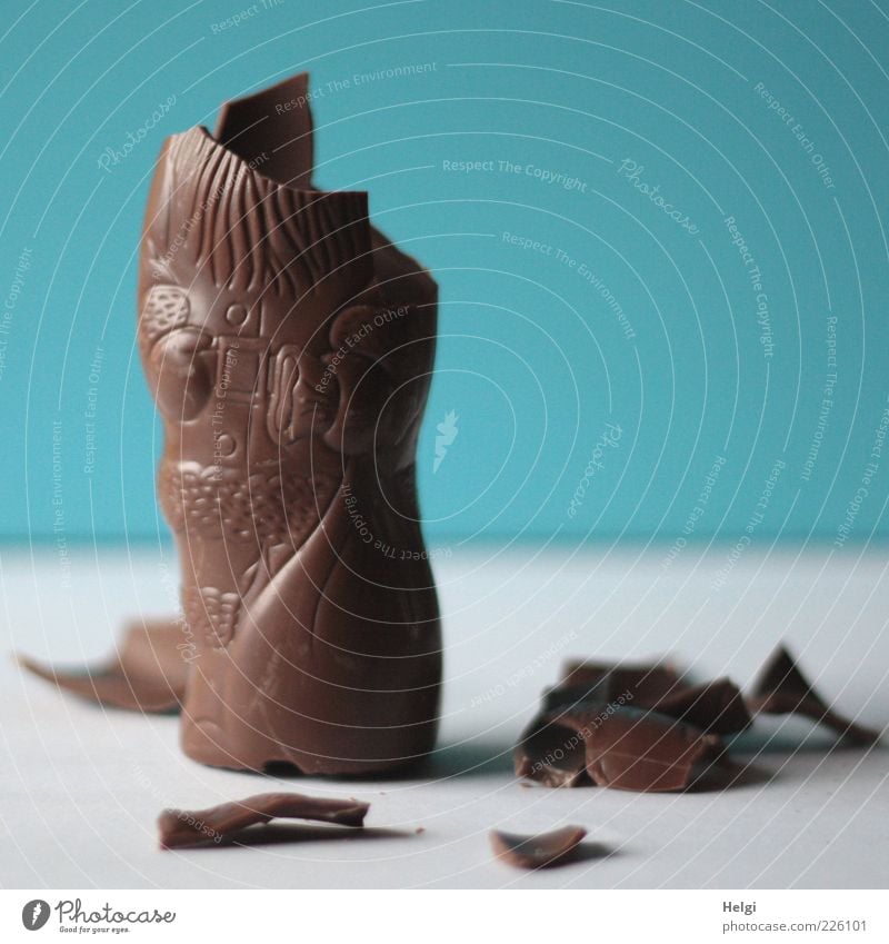 nibbled chocolate Santa Claus on a white table and blue wall Food Candy Chocolate Nutrition Lie Stand Authentic Simple Broken Small Delicious Sweet Blue Brown