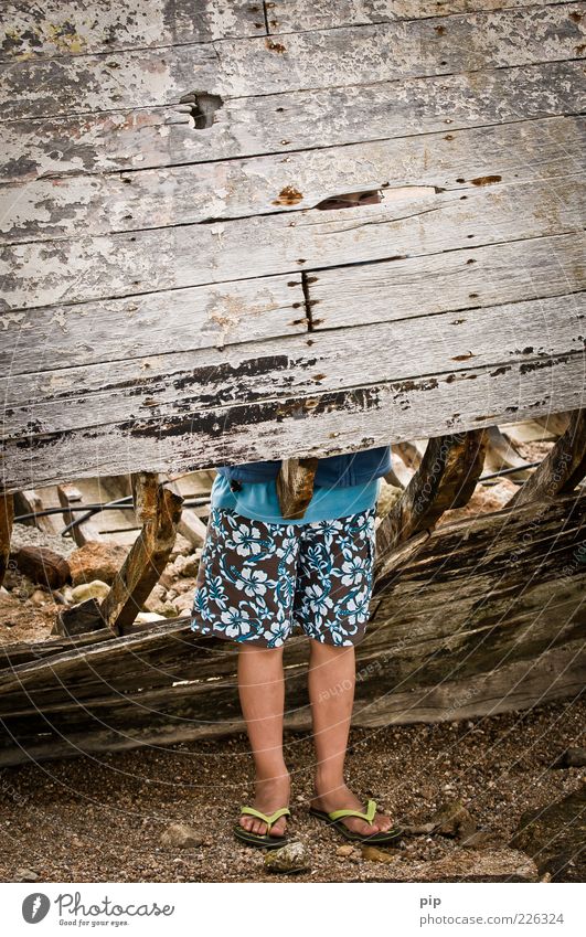 legroom Human being Boy (child) Legs Feet 1 Bermuda shorts Flip-flops Wood Metal Rust Looking Stand Old Dirty Boredom Slit Column Wreck Watercraft Putrid