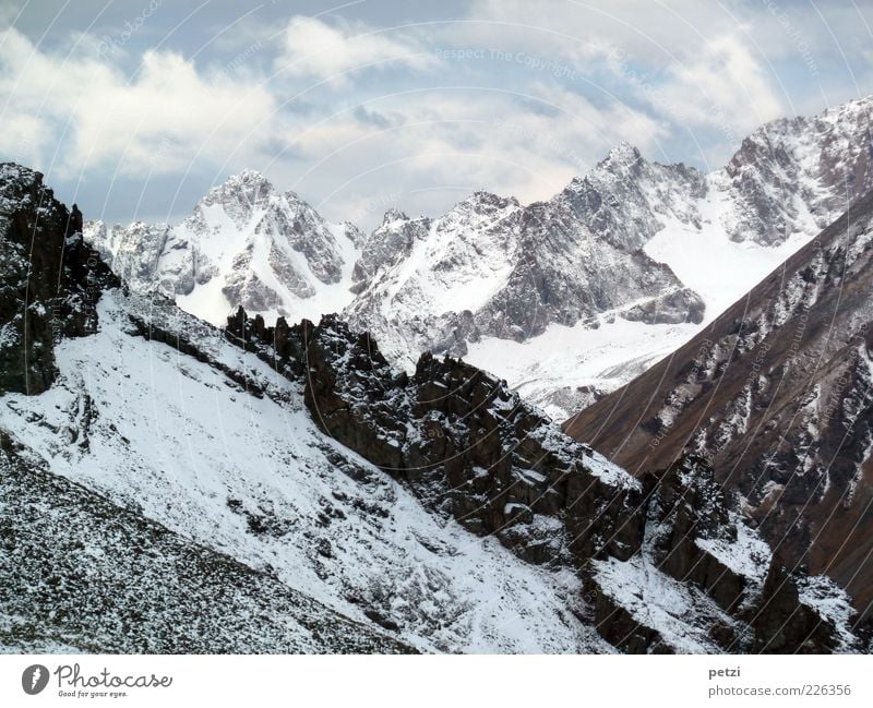 Impressive mountain world Environment Nature Landscape Sky Winter Snow Rock Mountain Peak Snowcapped peak Stone Fantastic Far-off places Gigantic Tall Blue