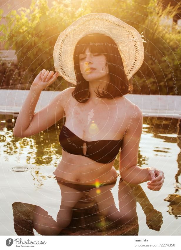 Young woman enjoying a sunny day in a pool Lifestyle Elegant Style Joy Beautiful Body Healthy Wellness Well-being Senses Relaxation Swimming pool