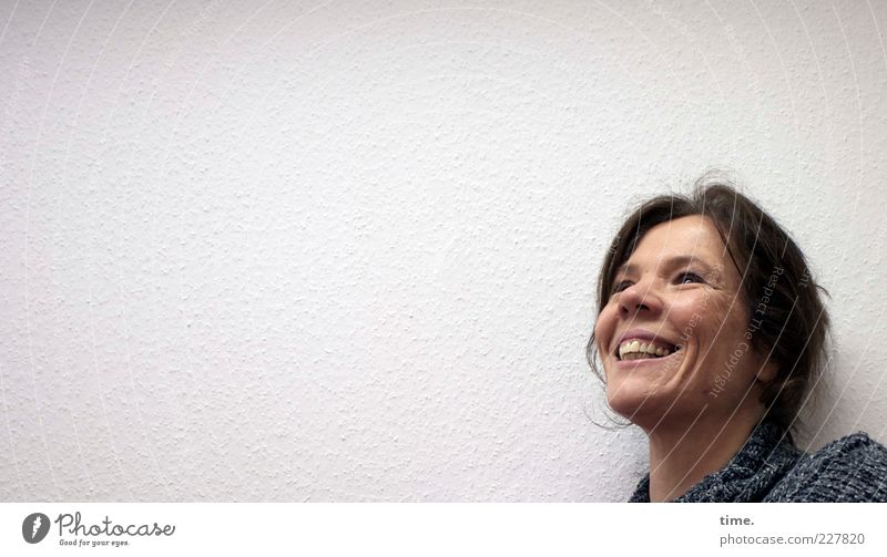 laughing woman in front of wall looking upwards Joy Hair and hairstyles Face Life Human being Feminine Woman Adults Head Nose 1 30 - 45 years Smiling Laughter