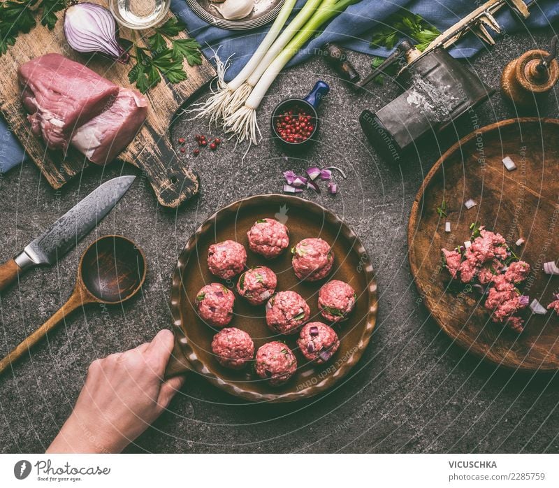 Hand holding pan with meatballs Food Meat Herbs and spices Nutrition Dinner Organic produce Crockery Pan Knives Spoon Style Design Living or residing Table