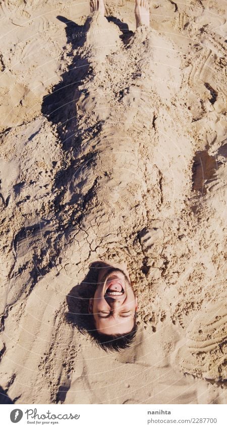 Young man buried in sand Lifestyle Joy Vacation & Travel Adventure Freedom Summer Summer vacation Sun Beach Human being Masculine Youth (Young adults) Man