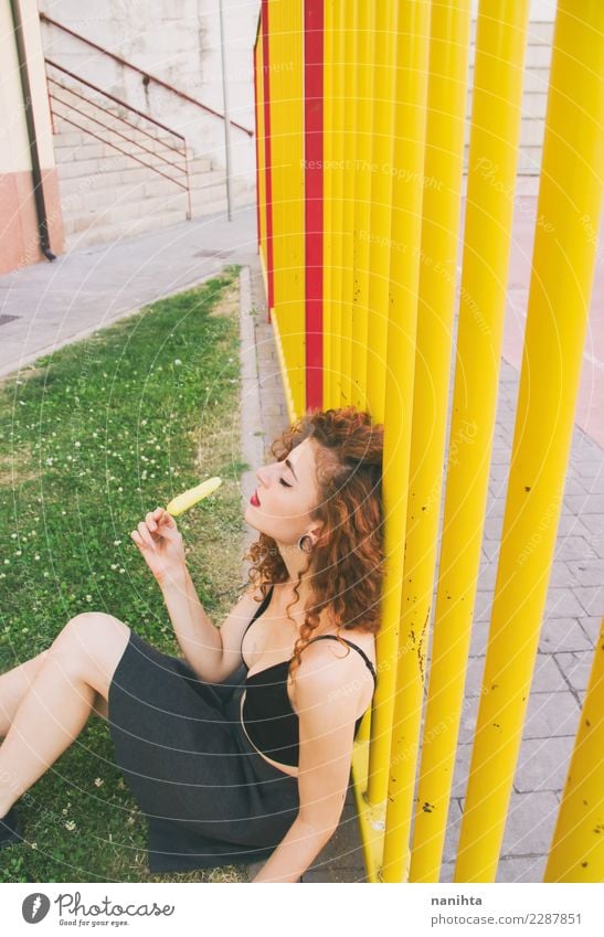 Young woman in a park enjoying a lemon ice cream Food Ice cream Eating Lifestyle Style Design Body Hair and hairstyles Wellness Senses Relaxation Schoolyard