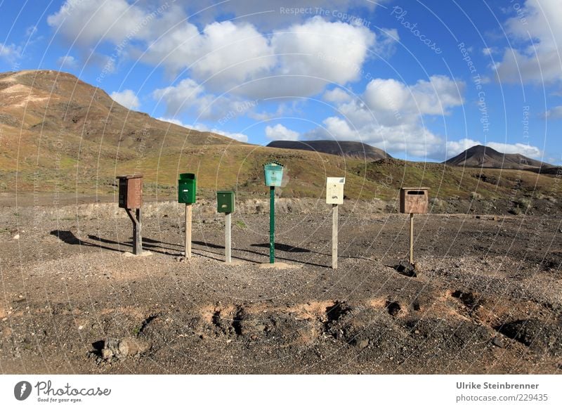 Six individual letterboxes stand in the volcanic landscape of Fuerteventura Vacation & Travel Zip code Mailbox Longing Loneliness Row 6 Box Expectation Gloomy