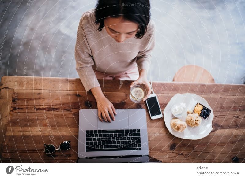 Young adult woman working on laptop in cafe Eating Breakfast Coffee Plate Lifestyle Table Work and employment Office Business PDA Computer Notebook Human being