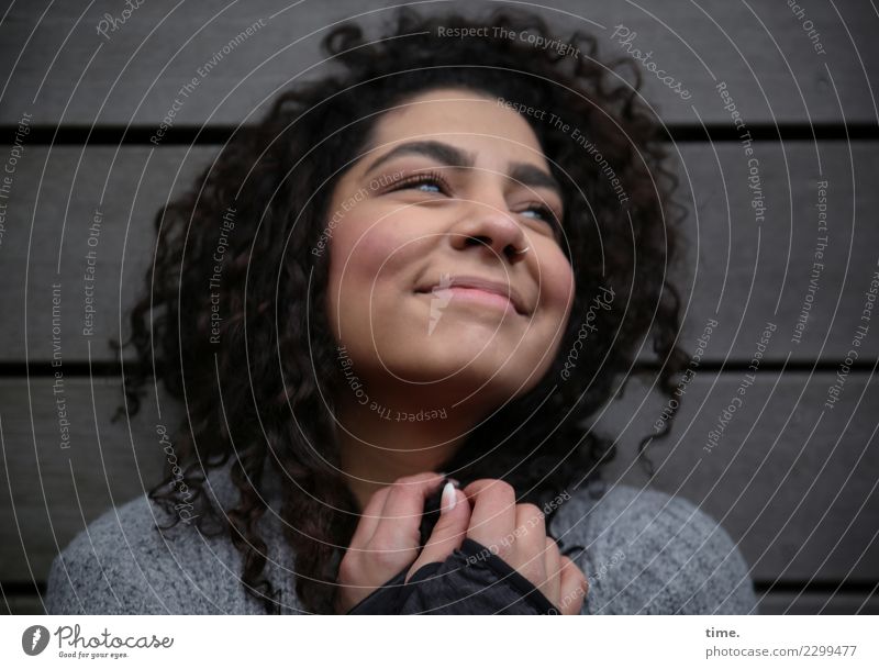 Woman, smiling contentedly Feminine Adults 1 Human being Wall (barrier) Wall (building) Sweater Brunette Long-haired Curl Relaxation To hold on Smiling Looking