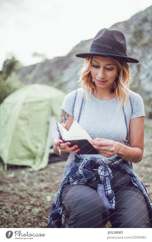 young hiking woman taking notes at camp Lifestyle Leisure and hobbies Vacation & Travel Trip Adventure Far-off places Freedom Camping Mountain Hiking