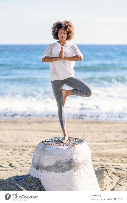 Young black woman doing yoga in the beach. Lifestyle Beautiful Hair and hairstyles Wellness Relaxation Meditation Leisure and hobbies Beach Ocean Sports Yoga