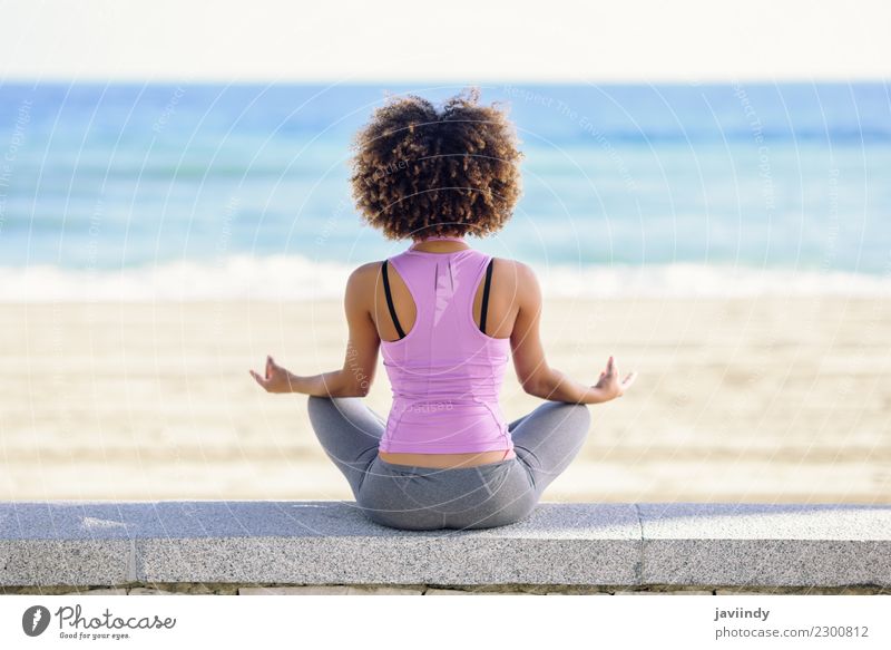 Black woman, afro hairstyle, doing yoga in the beach. Lifestyle Beautiful Hair and hairstyles Wellness Relaxation Meditation Leisure and hobbies Beach Ocean