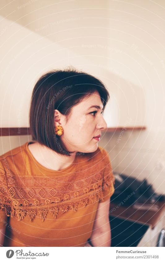 Young woman sitting in her kitchen Feminine Youth (Young adults) Woman Adults 1 Human being 18 - 30 years Living or residing Kitchen Sit Brunette Earring