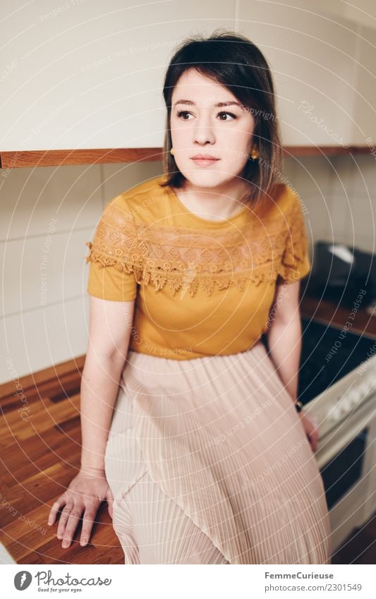 Young woman sitting in kitchen Elegant Style Feminine Youth (Young adults) Woman Adults 1 Human being 18 - 30 years Living or residing Kitchen Sit Wood Skirt