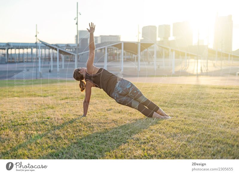 Beautiful girl is engaged in yoga in the park Lifestyle Harmonious Relaxation Sports Yoga Woman Adults Youth (Young adults) Nature Grass Park Sit Green Power