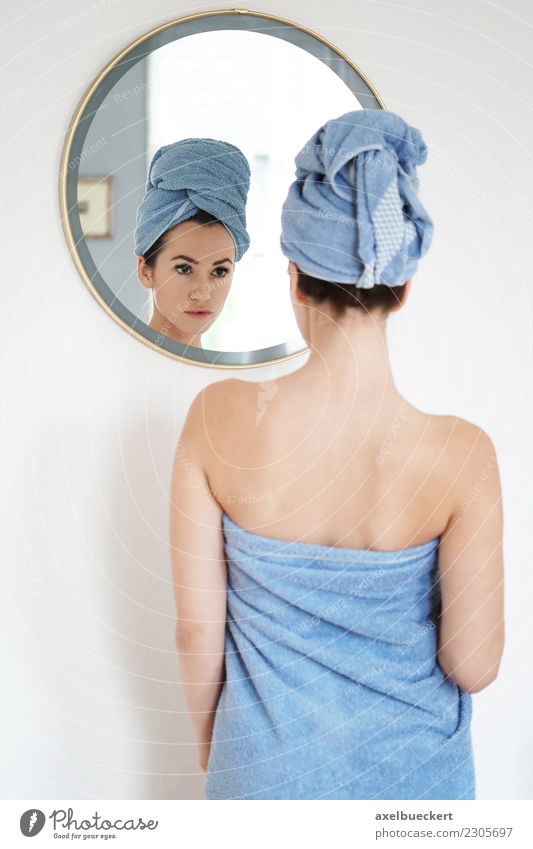 young woman wrapped in towel looks at herself in the mirror Lifestyle Beautiful Personal hygiene Wellness Flat (apartment) Mirror Bedroom Bathroom Human being