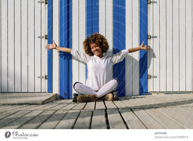 Young black woman on roller skates sitting on floor Lifestyle Joy Hair and hairstyles Leisure and hobbies Vacation & Travel Sports Human being Young woman