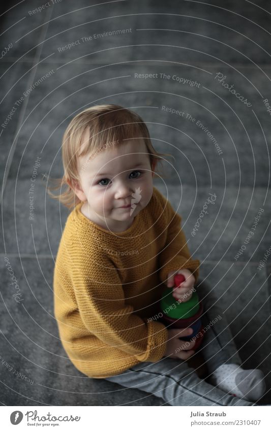 girl sitting on the ground playing with wooden tower Feminine Toddler Infancy 1 Human being 1 - 3 years Sweater Knitted sweater Blonde Short-haired Wooden toy