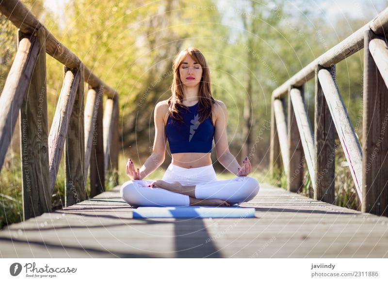 Woman doing yoga in nature. Lotus figure on wooden bridge. Lifestyle Body Relaxation Meditation Sports Yoga Human being Young woman Youth (Young adults) Adults