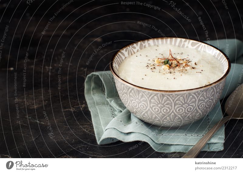 Creamy cauliflower soup in a bowl on a dark background Vegetable Soup Stew Herbs and spices Lunch Dinner Vegetarian diet Diet Bowl Spoon Table Child Gastronomy