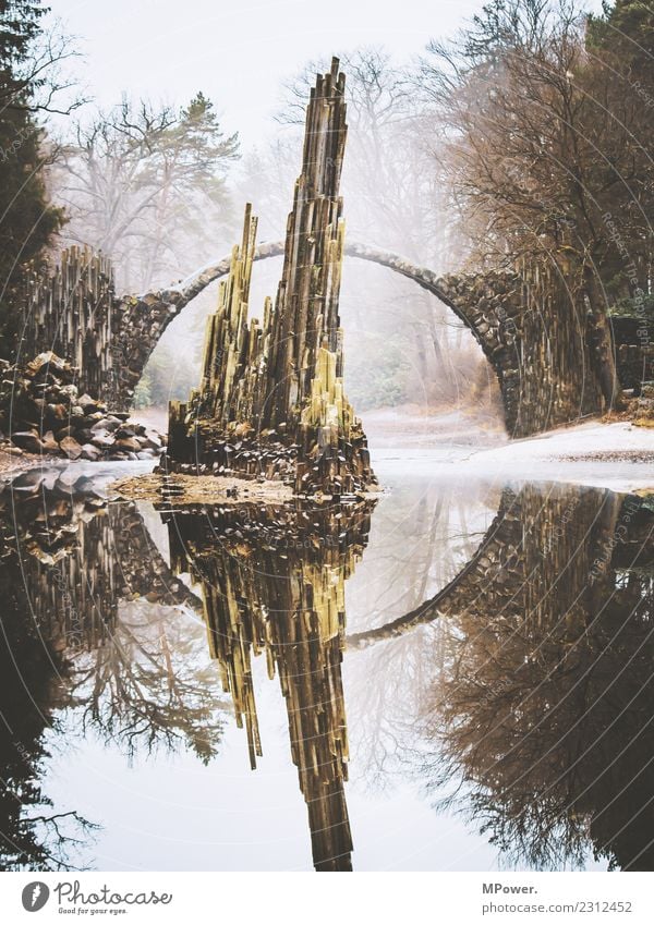 mystical place Environment Nature Water Bad weather Old Bridge Mystic Lake Reflection Rock Stone Rock formation Fog Rakotzbrücke Extraterrestrial Park Circular