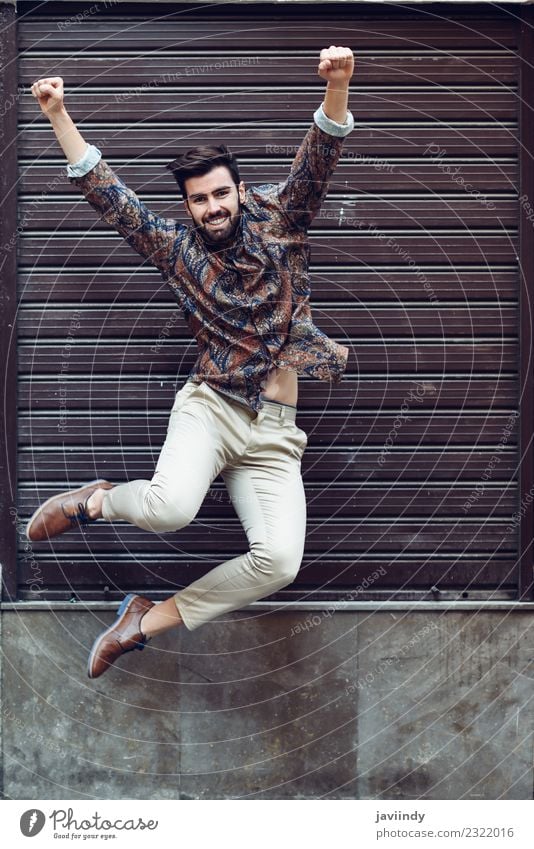 Young bearded man jumping in urban background Joy Human being Masculine Young man Youth (Young adults) Man Adults 1 18 - 30 years Street Fashion Shirt Beard