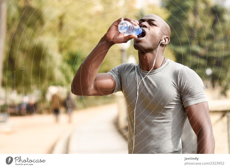 Young black man drinking water before running outdoors Drinking Bottle Lifestyle Body Sports Jogging Human being Masculine Young man Youth (Young adults) Man