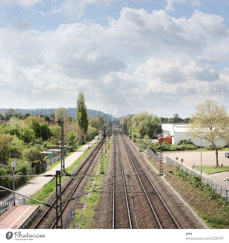 shuttle Sky Clouds Plant Tree Grass Bushes Manmade structures Building Rail transport Railroad tracks Railroad system Colour photo Exterior shot Deserted