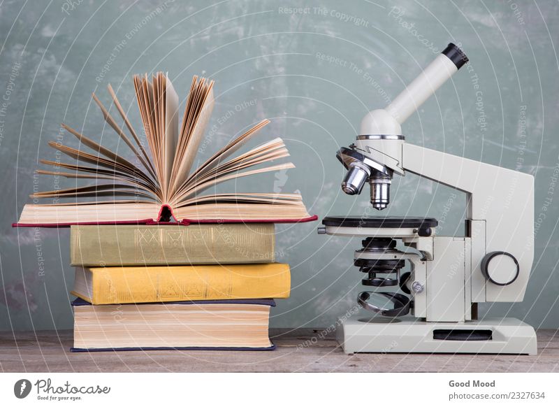 books and microscope on the desk on green background Desk Table Science & Research School Study Classroom Academic studies Laboratory Book Library Microscope