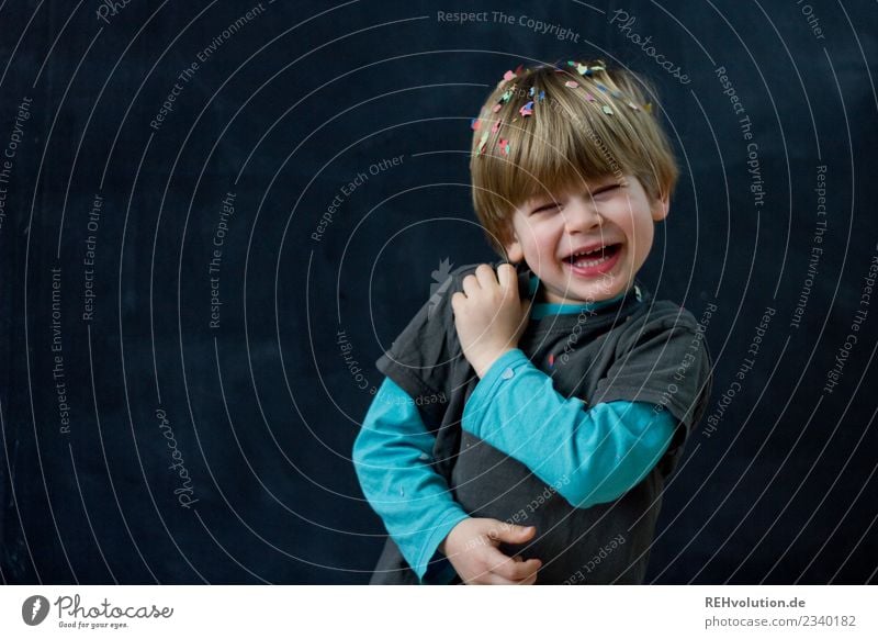 child laughs with confetti in front of a black wall Joy luck Leisure and hobbies Playing Human being Child Boy (child) Face 1 1 - 3 years Toddler 3 - 8 years