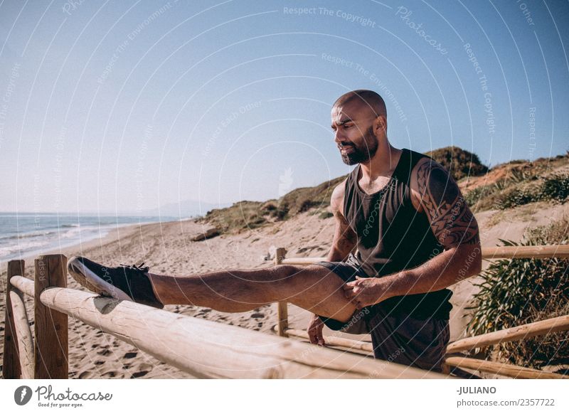 tough muscular man is doing stretching at railing to beach Young man Sports workout Beach Fitness Sports Training Hard Perspire Musculature Joy Sportsperson