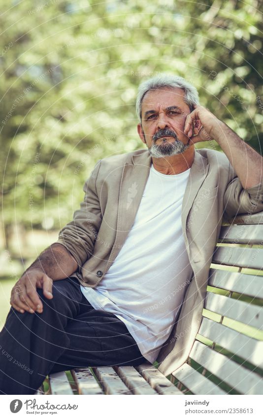 Pensive mature man sitting on a bench in an urban park Lifestyle Happy Retirement Human being Man Adults Male senior Senior citizen 1 45 - 60 years