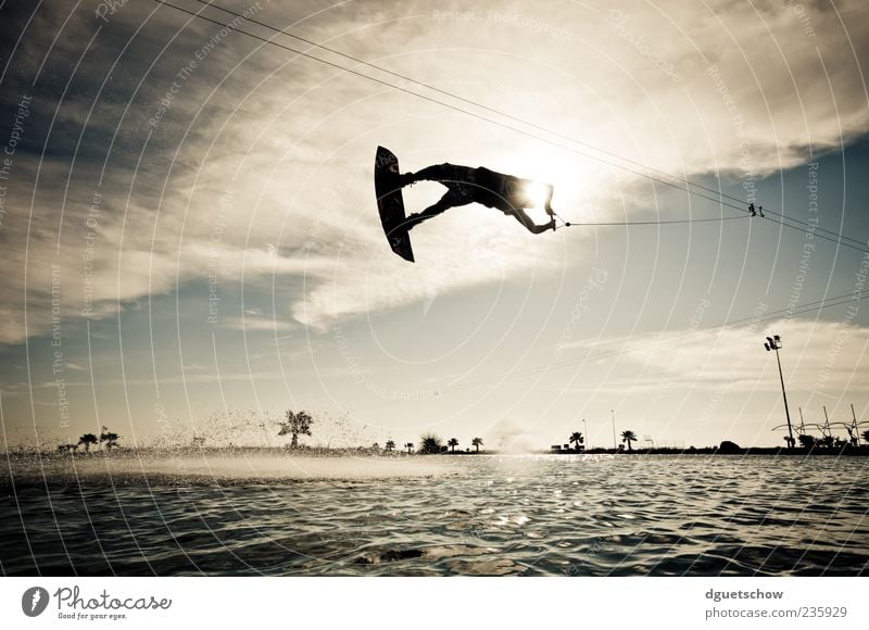 flying high Joy Leisure and hobbies Summer Sports Aquatics Masculine Man Adults Air Water Clouds Sunlight Flying Subdued colour Exterior shot Day Light Contrast