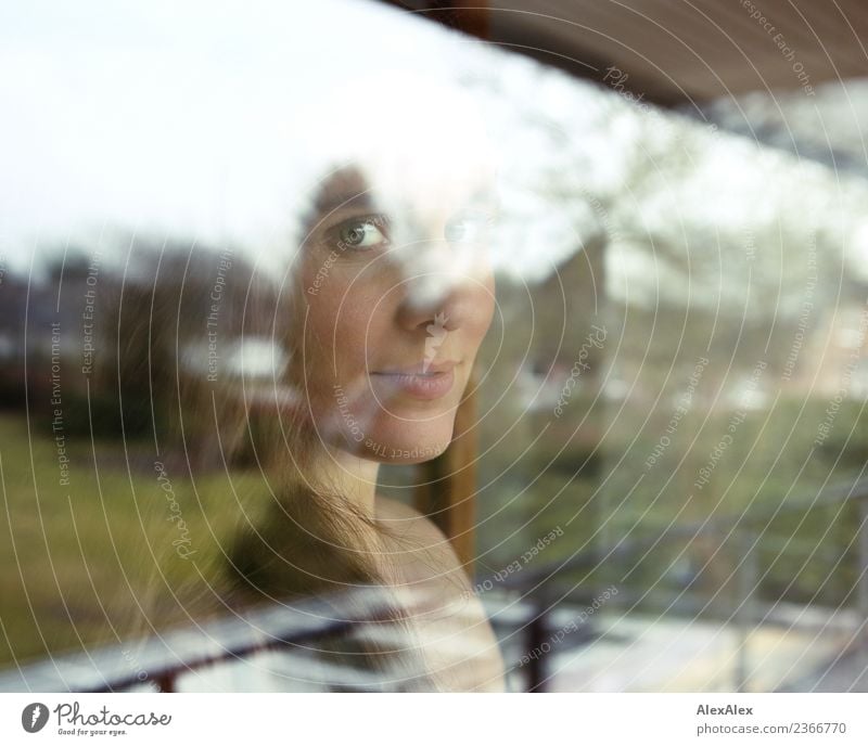 Portrait of a beautiful young woman behind a window pane with reflections and reflexions Lifestyle Style pretty Harmonious Flat (apartment) Window Balcony